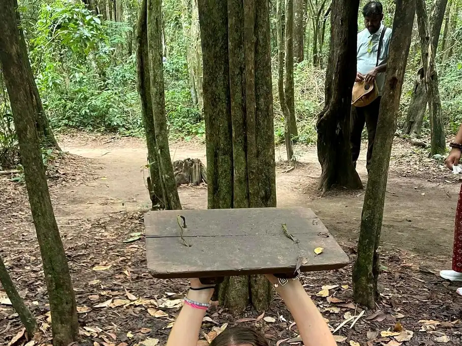 Guide expliquant le reseau des tunnels de Cu Chi a un groupe de visiteurs